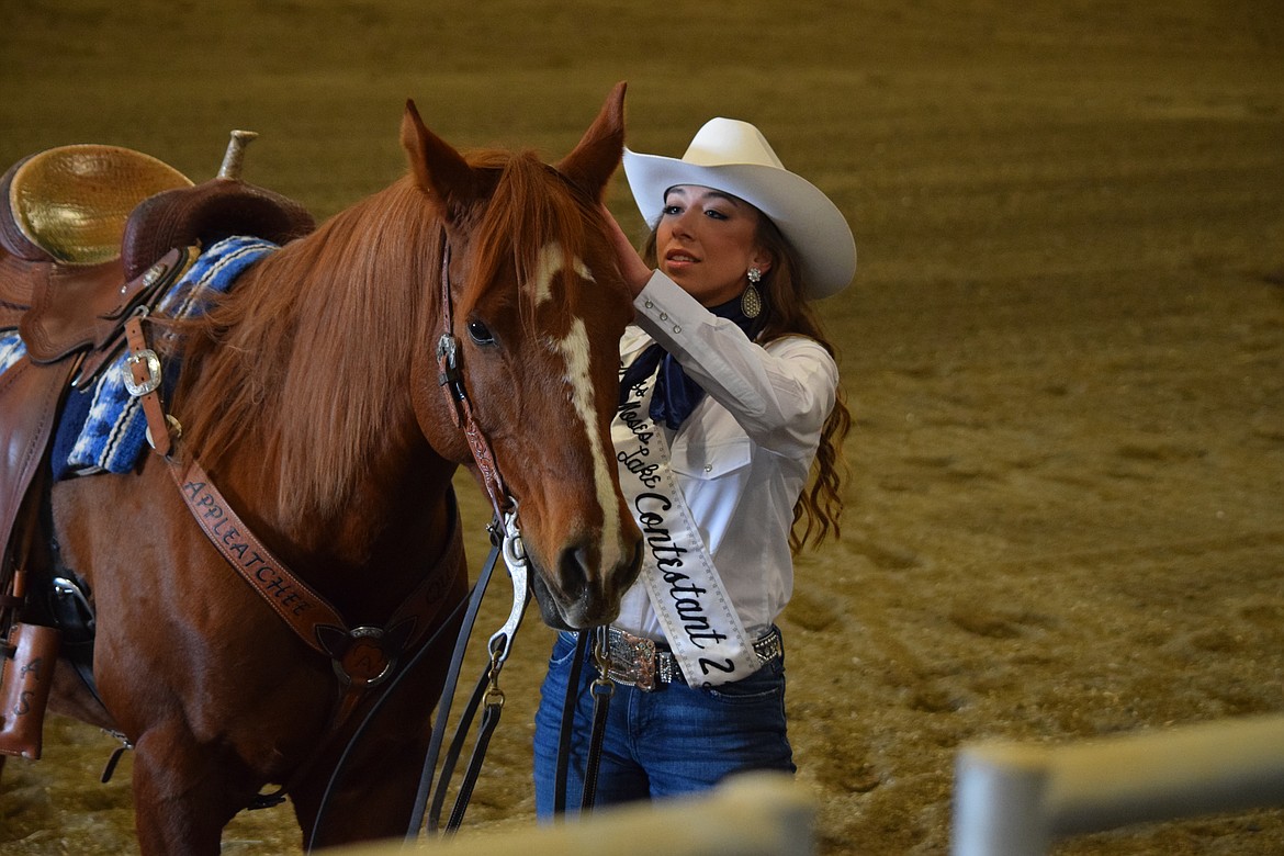 Miss Moses Lake Roundup contestant Alexis Shoults prepares to unbuckle her horse’s bridle and speak with the judges as part of the pageant’s horsemanship competition on Saturday.