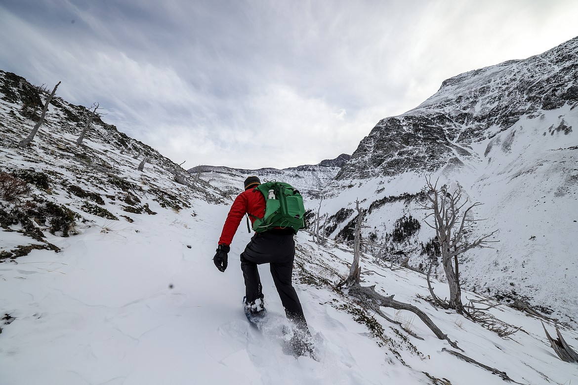 A hiker charges up a snowy hill in snowshoes. (JP Edge photo)