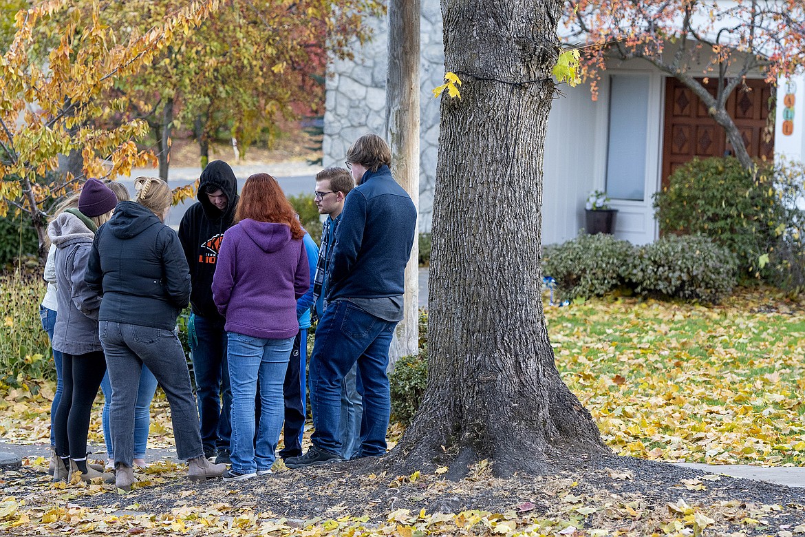 People gather to pray outside of the Pi Beta Phi sorority house at the University of Idaho after four students were found dead at an apartment complex south of campus, including two sorority members, on Monday, Nov. 14, 2022, in Moscow, Idaho. The Moscow Police Department has labeled the deaths as “homicides” but maintains there is not an active risk to the community. (Zach Wilkinson//The Moscow-Pullman Daily News via AP)
