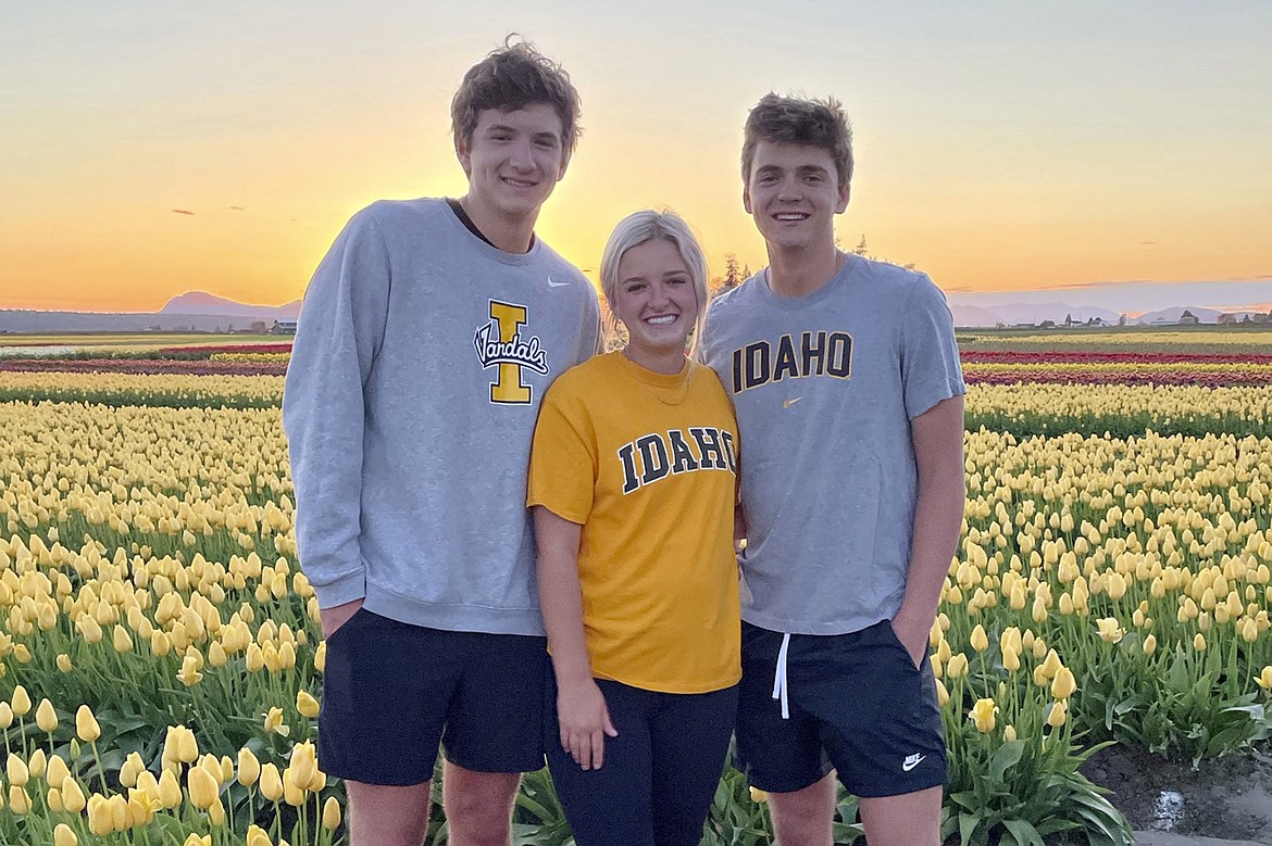 In this photo provided by Stacy Chapin, triplets Ethan, Maizie and Hunter Chapin pose in front of a tulip field in La Conner, Wash., in April of 2021. Ethan Chapin was one of four University of Idaho students found stabbed to death in a home near the Moscow, Idaho campus on Sunday, Nov. 13, 2022. Police are still searching for a suspect in the case.