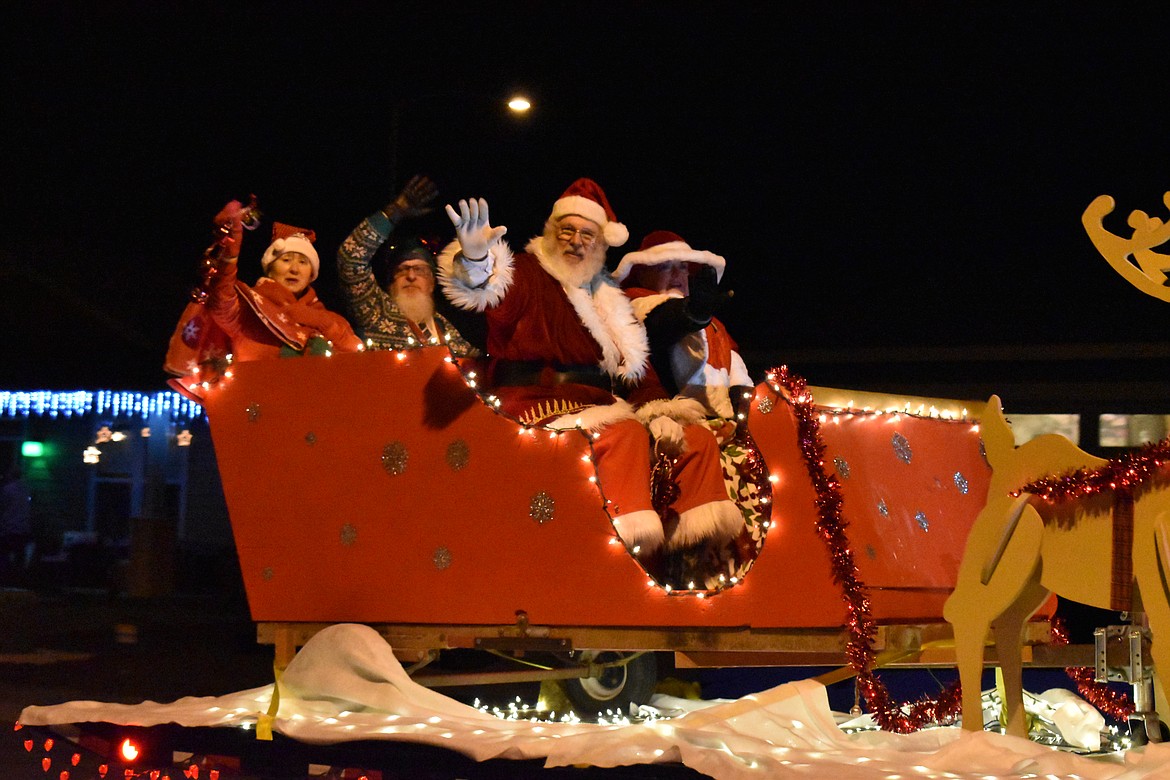 Santa, Mrs. Santa and their escorts wave to the crowd during one night of the 2021 Santa Parade in Quincy.
