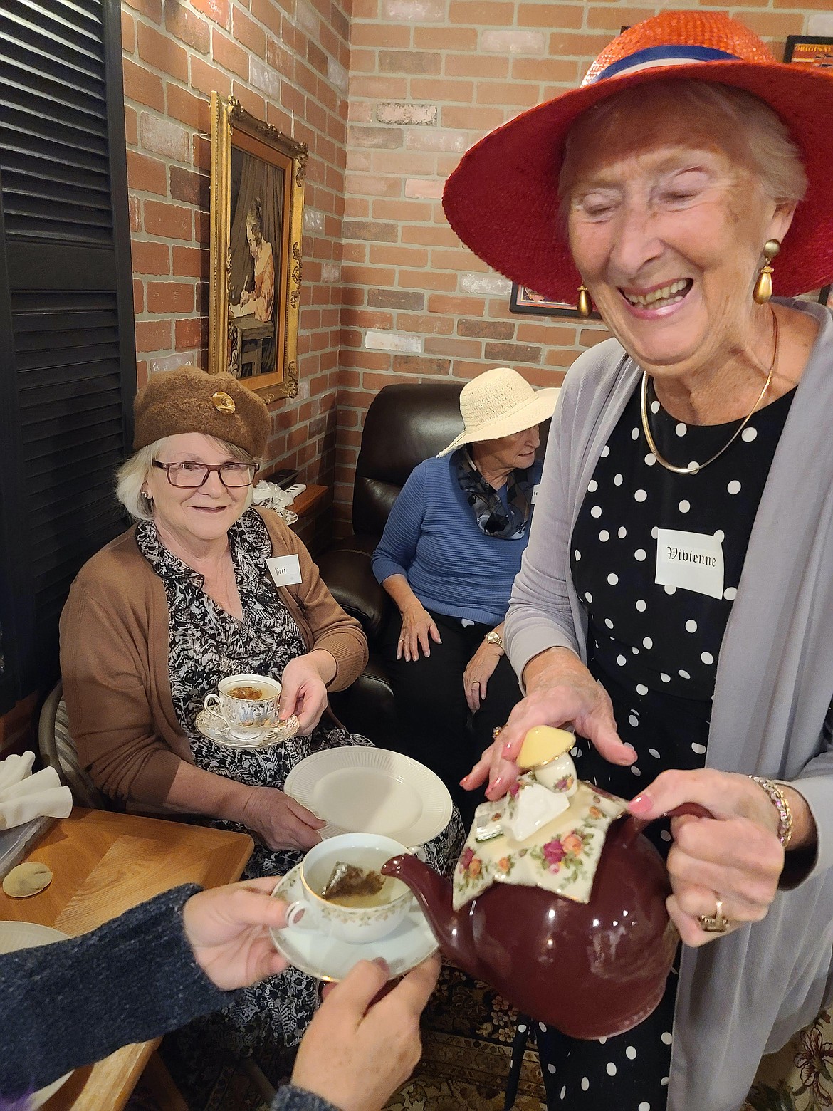 Vivienne Montague, former owner of Vivienne's Fifth Street Cafe, serves tea to the women of Easthaven Church while sharing stories about her life at a tea held Oct. 29 in her honor. (photo provided)