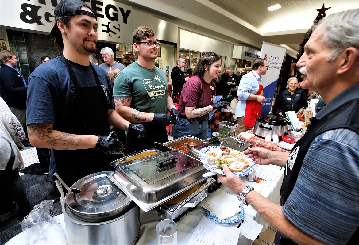 Daft Badger's team, from left, Averee Rowland, Chad Aga and Sarah Aga greet guests at Souport the End of Homelessness on Thursday.