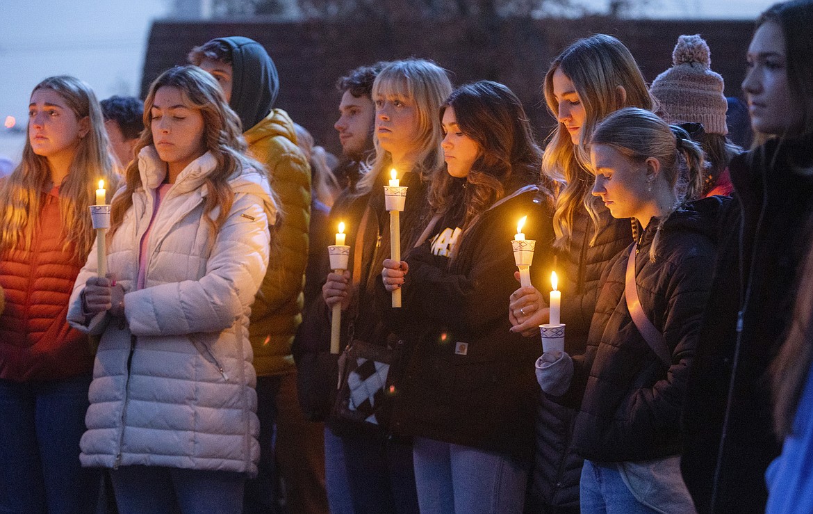 Boise State University students, along with people who knew the four University of Idaho students who were found killed in Moscow, Idaho, days earlier, pay their respects at a vigil held in front of a statue on the Boise State campus, Thursday, Nov. 17, 2022, in Boise, Idaho. Autopsies performed on the four students who were found dead inside a rental house near campus showed that all four were stabbed to death, the Latah County coroner said. (Sarah A. Miller/Idaho Statesman via AP)