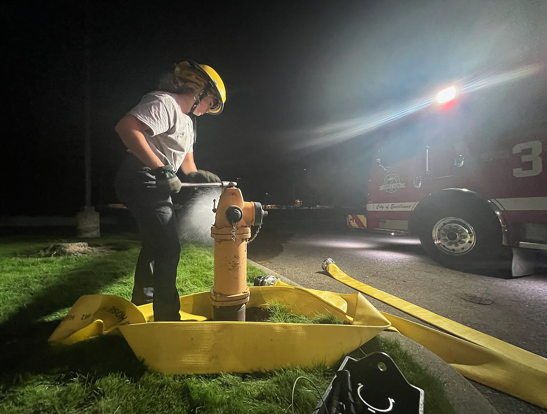 Coeur d'Alene High School senior Jane Schlosser hooks a hose to a hydrant while on shift as a cadet with the Coeur d'Alene Fire Department.