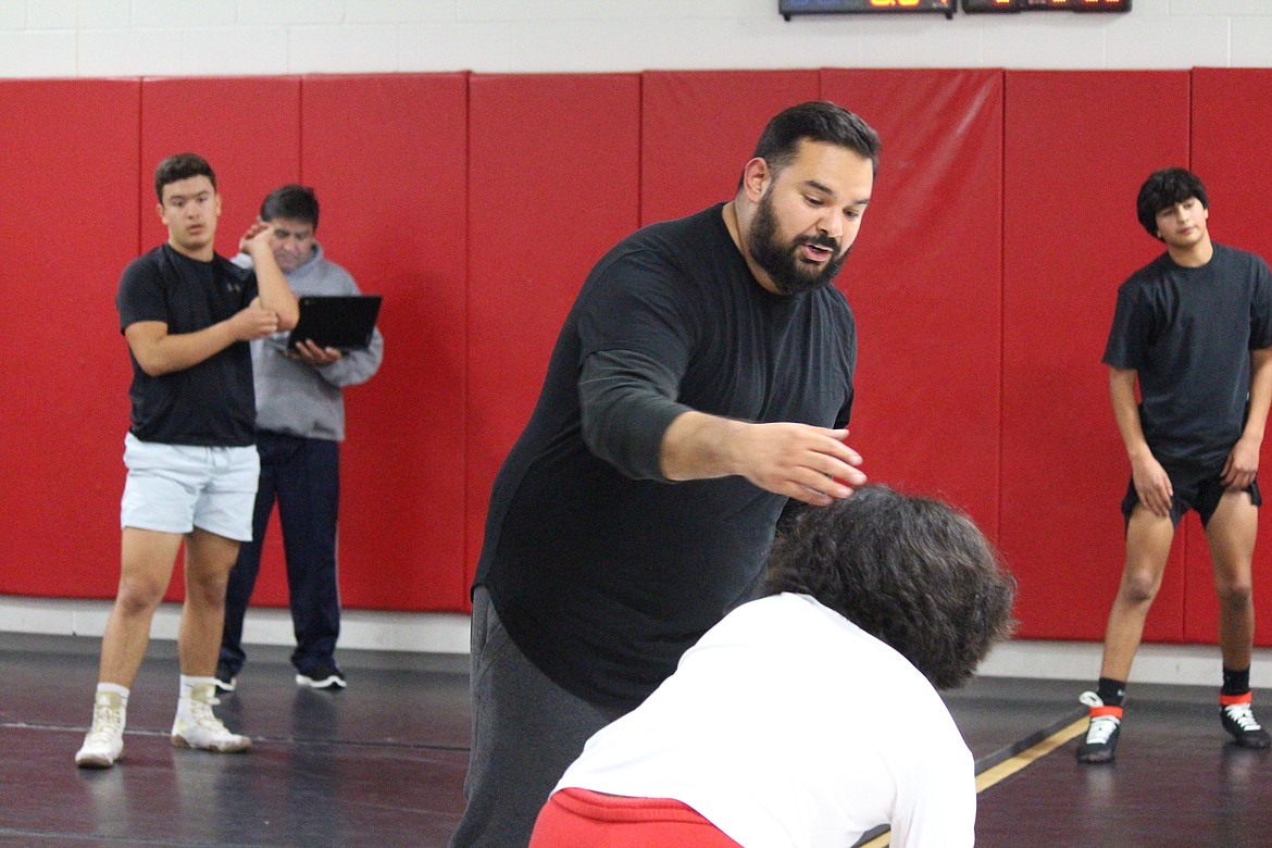 Othello wrestling coach Rudy Ochoa II instructs the team in a move during practice.