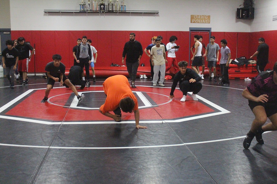 Warmups at Othello wrestling practice include some front somersaults.