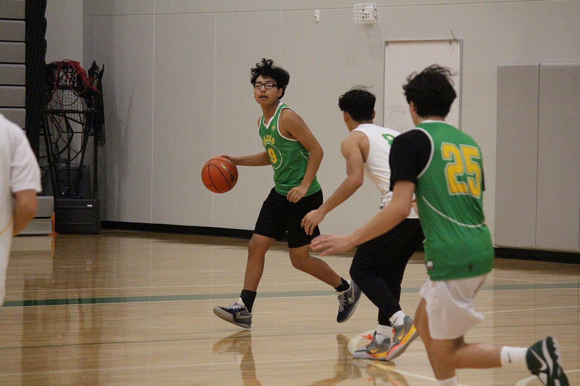 Quincy basketball players run a play during practice.