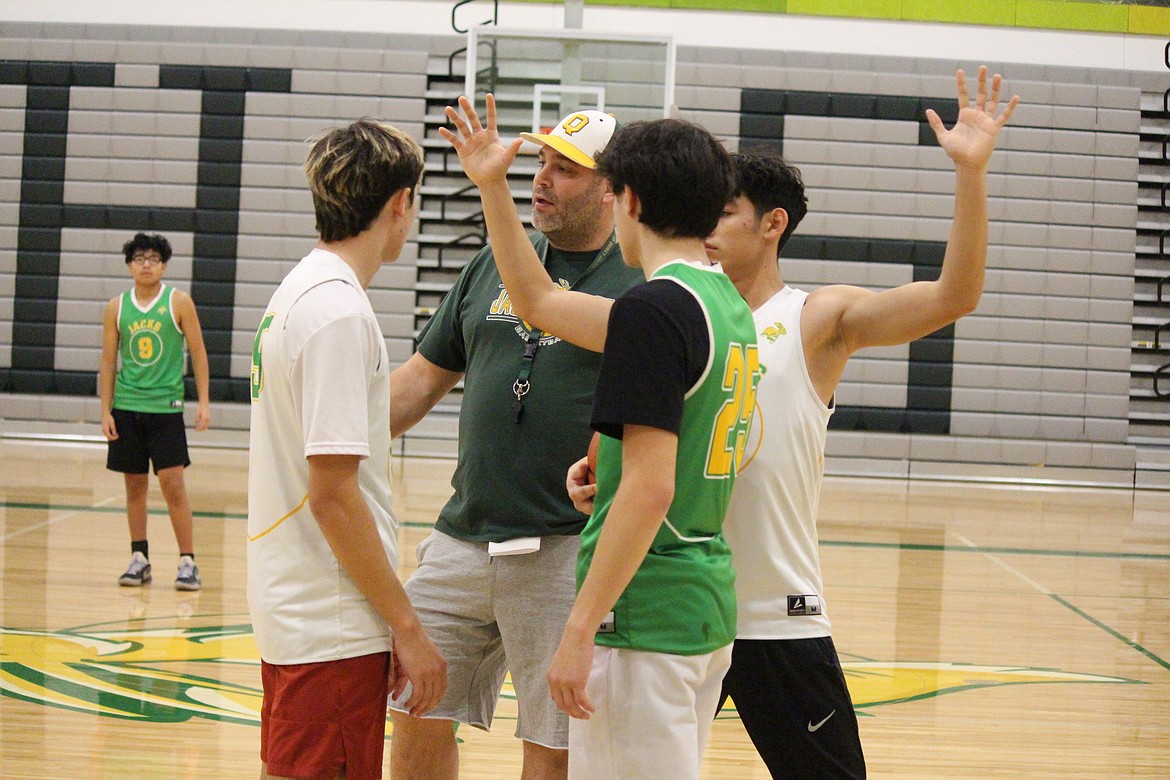 Quincy head basketball coach Scott Bierlink (in hat) and his players work out the details of their defensive play during practice.