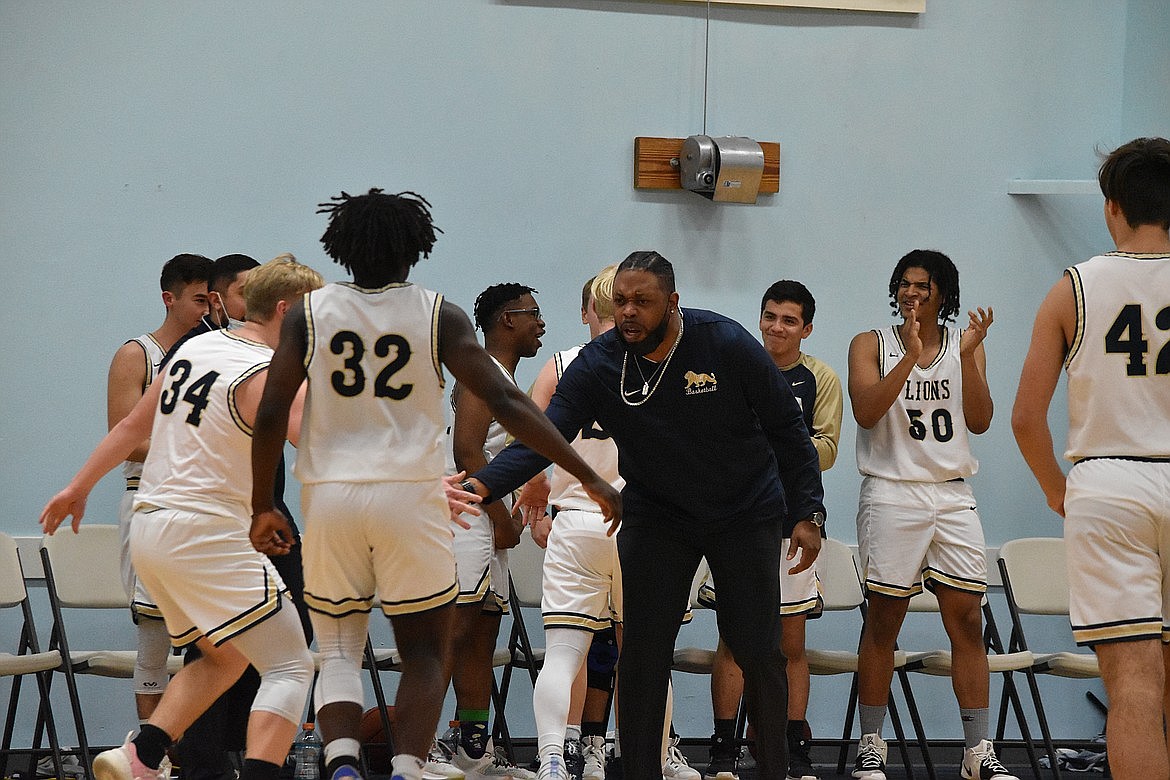 MLCA/CCS boy’s basketball Head Coach Emerson Ferguson high-fives players coming off the court during a game against Cascade Christian Academy last season.