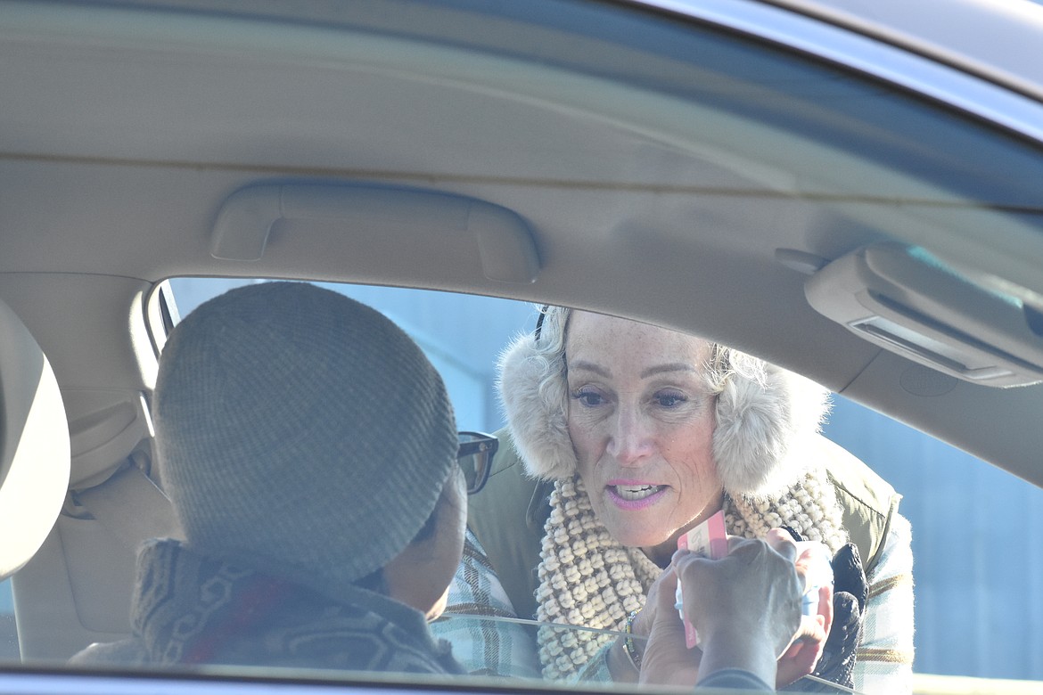 Lisa Chapman-Rosa hands a carton of eggs to a client during the Moses Lake Food Bank’s distribution on Monday.