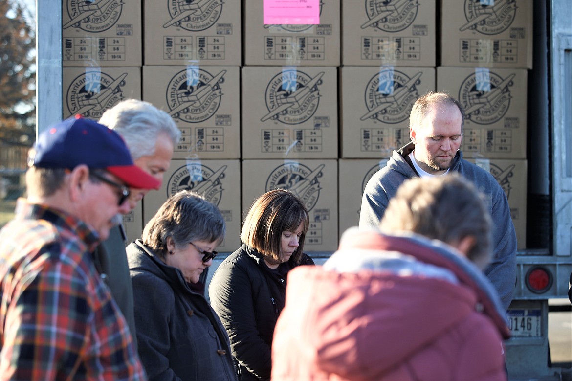 Volunteers gather to pray outside the trailer packed with Operation Christmas Child shoeboxes on Monday on the final day of National Collection Week.