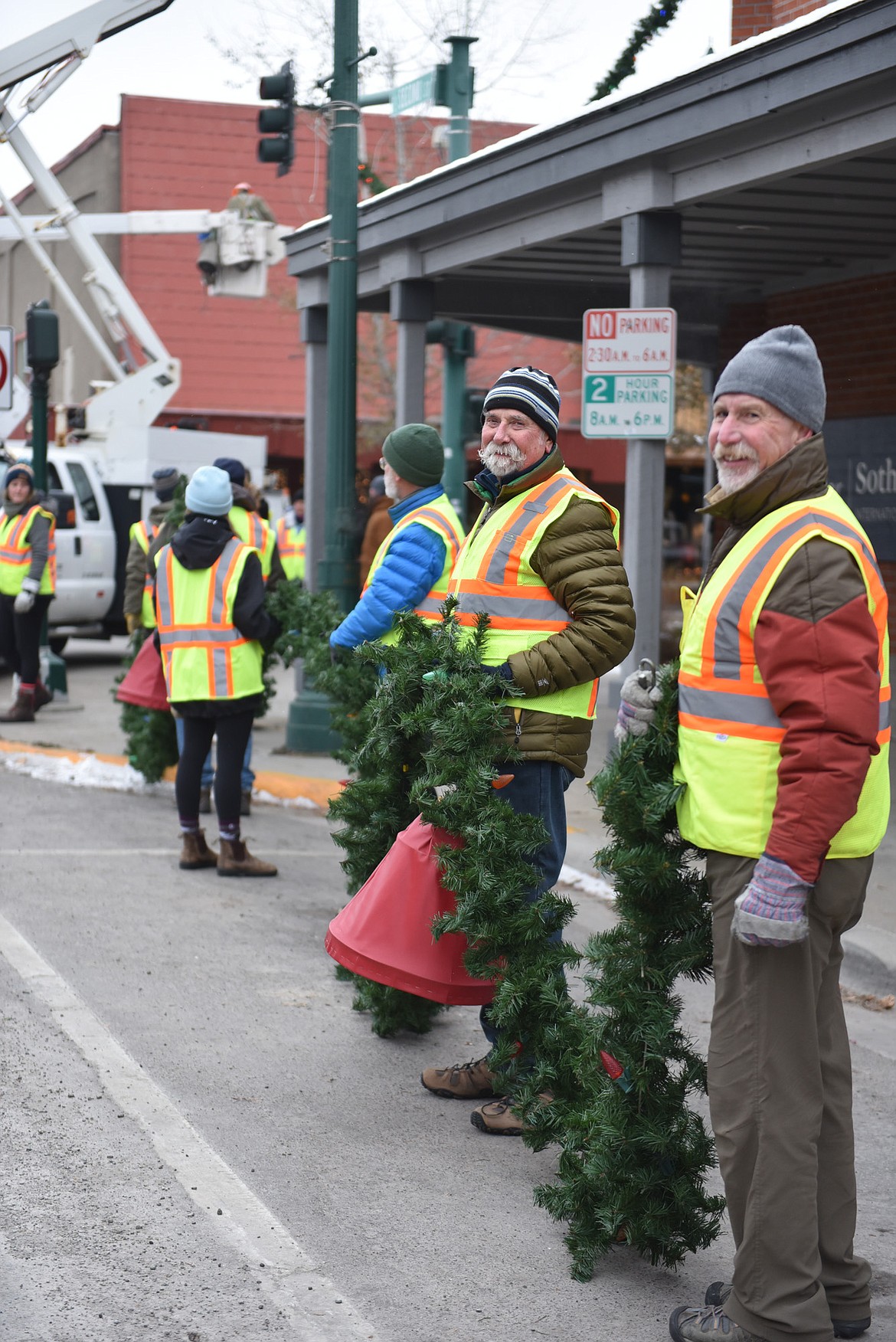 Volunteers help with a garland on Sunday morning. (Julie Engler/Whitefish Pilot)