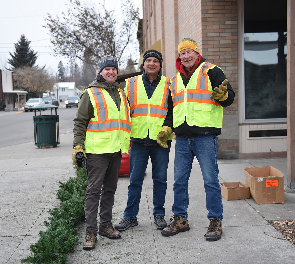 Volunteers help with the decorations in downtown Whitefish on Sunday morning. (Julie Engler/Whitefish Pilot)