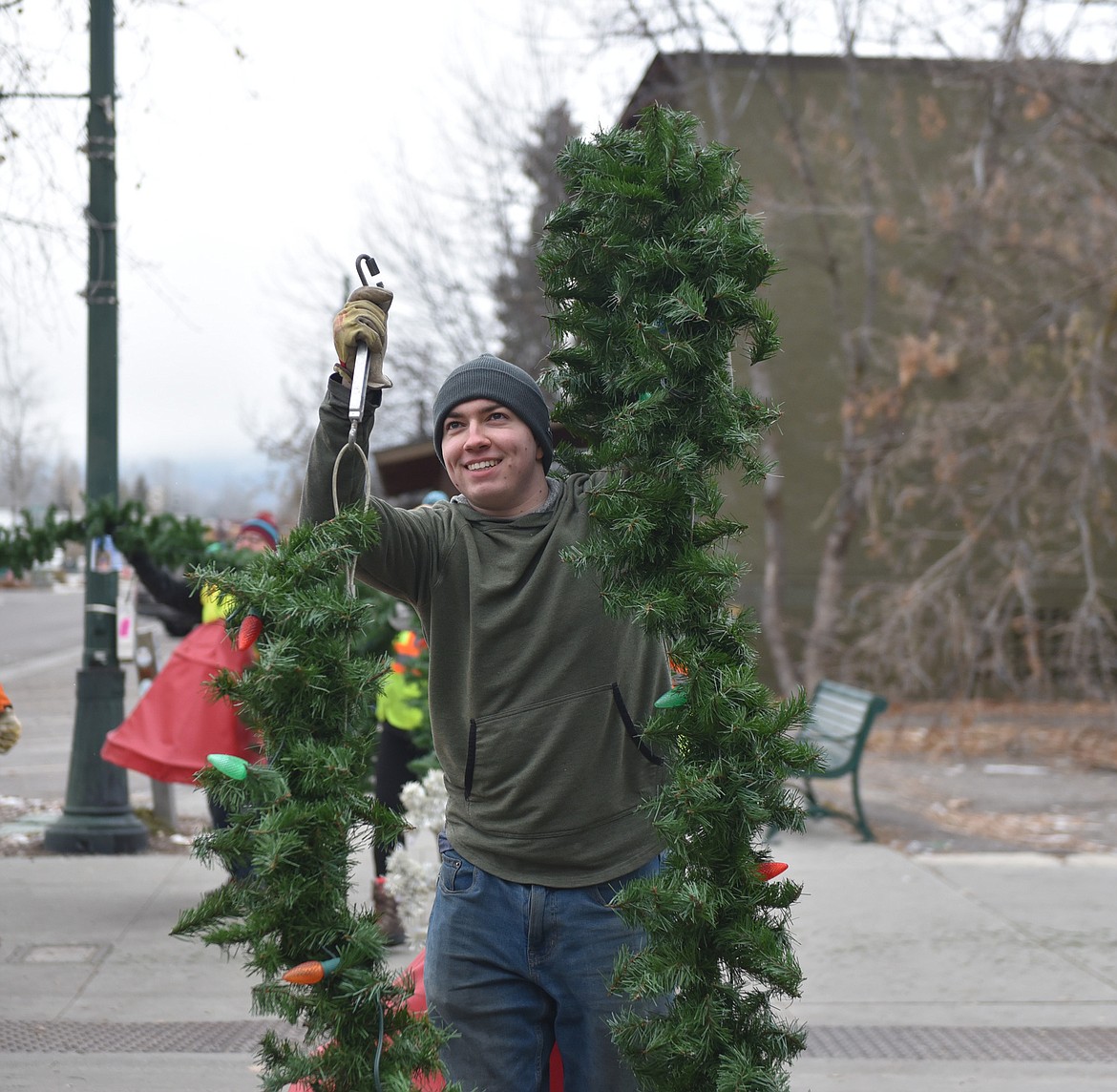 A volunteer helps with the garlands Sunday morning. (Julie Engler/Whitefish Pilot)