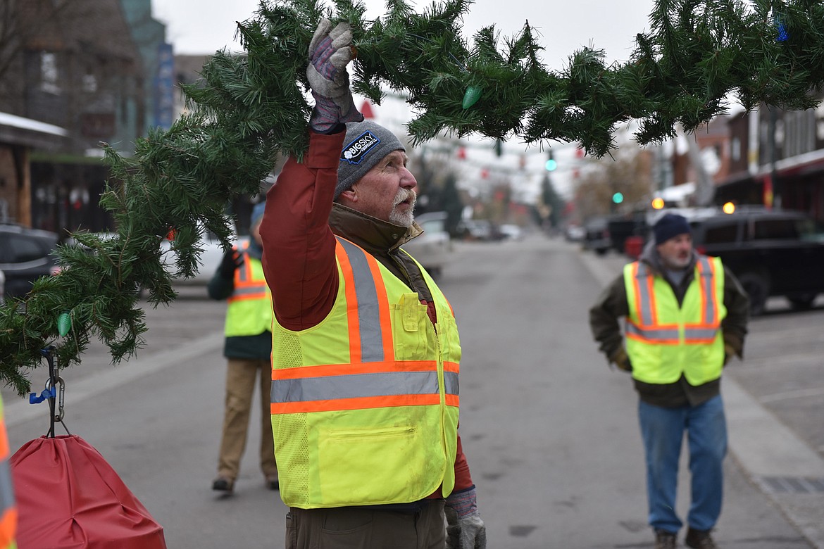 A volunteer helps with a garland on Sunday morning. (Julie Engler/Whitefish Pilot)