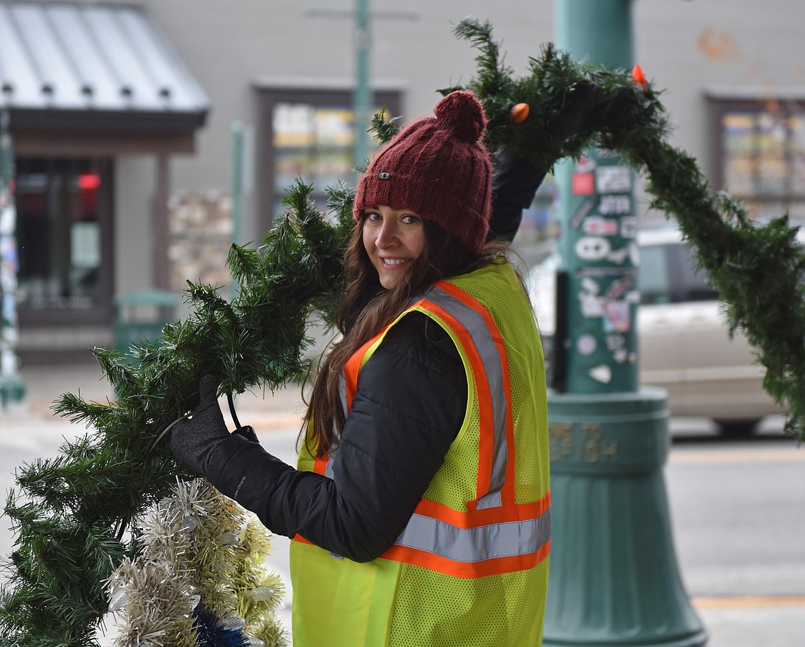 A volunteer helps with a garland on Sunday morning. (Julie Engler/Whitefish Pilot)