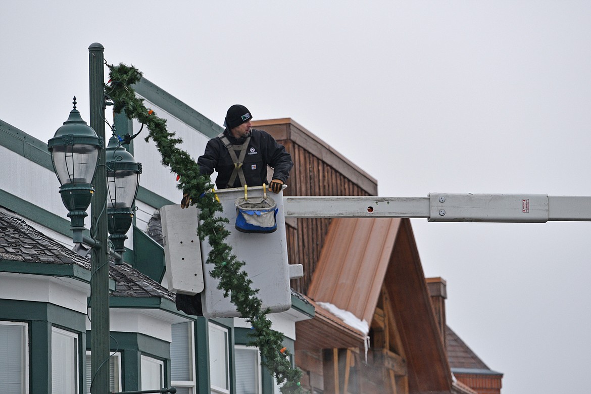 A crew member from FEC helps with the decorations Sunday morning.(Julie Engler/Whitefish Pilot)