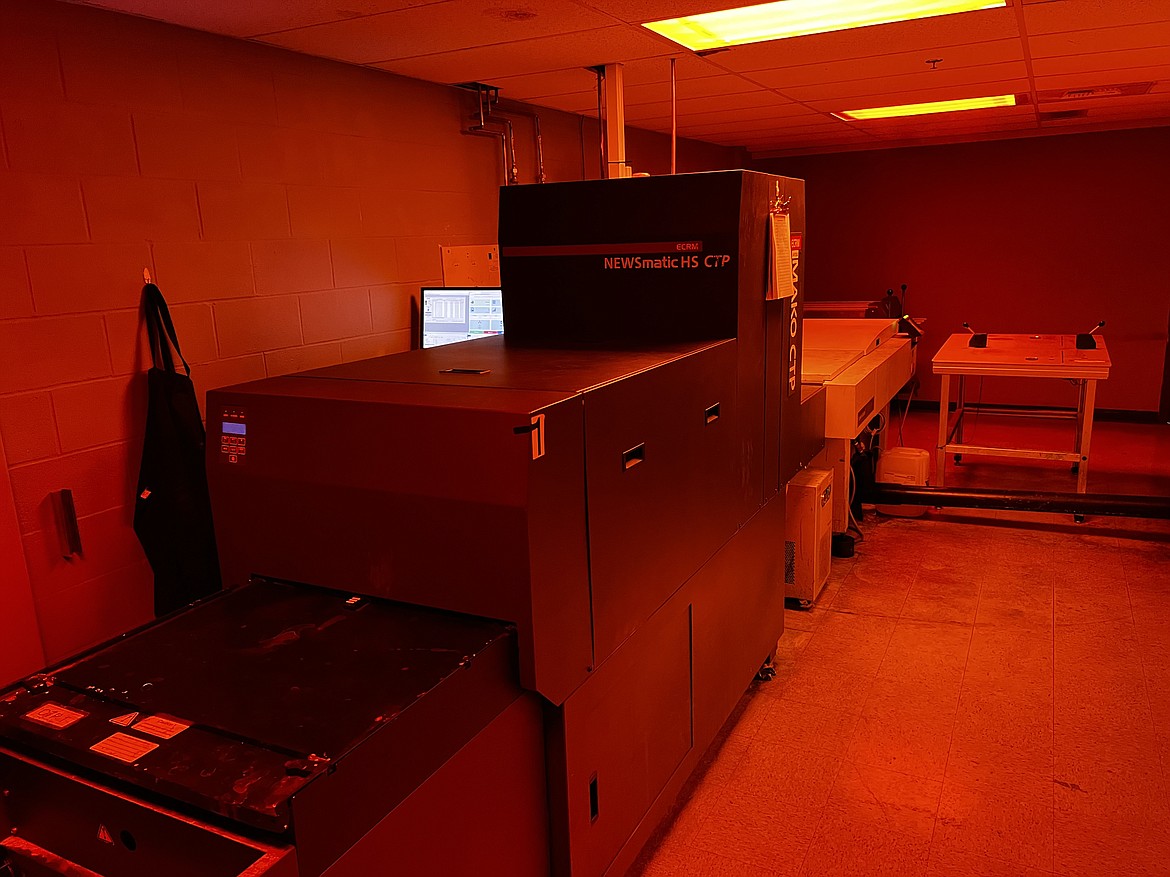 The plating room is keep under red lights to reduce light exposure that could damage the plates that newspapers are print on.