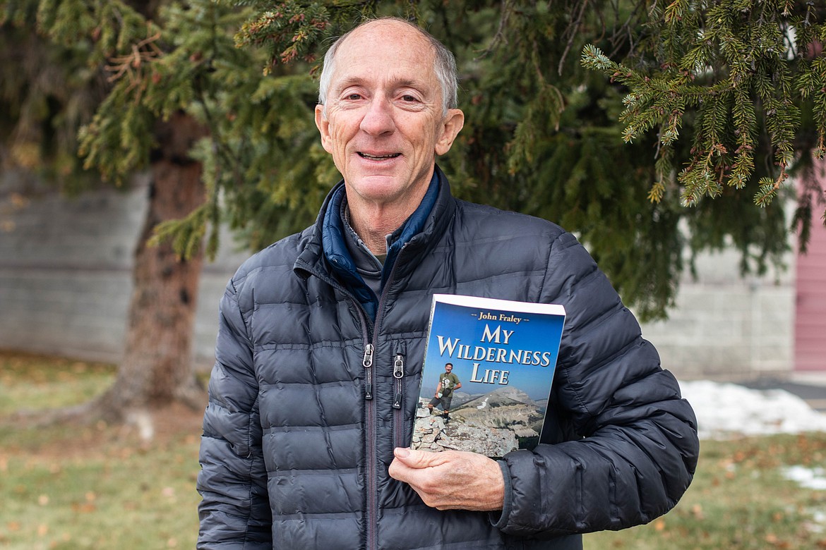 John Fraley poses for a portrait at the Flathead Valley Community College on Nov. 22, 2022, holding his newest book, an adventure memoir called "My Wilderness Life." (Kate Heston/Daily Inter Lake)