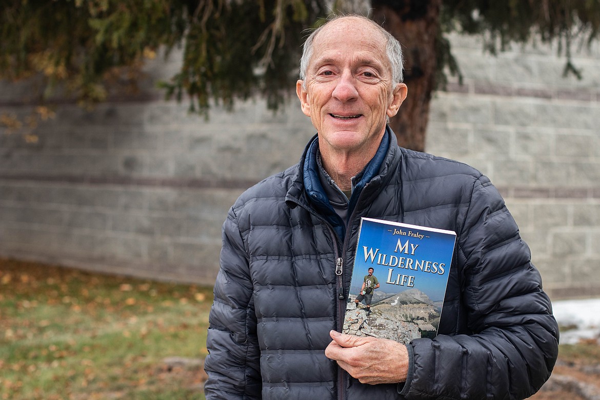 John Fraley poses for a portrait at the Flathead Valley Community College on Nov. 22, 2022, holding his newest book, an adventure memoir called "My Wilderness Life." (Kate Heston/Daily Inter Lake)