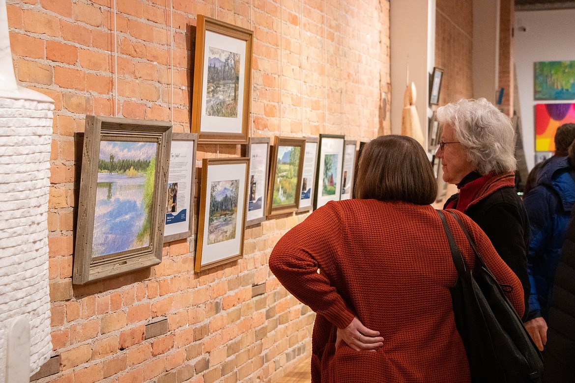 Patrons look at the artwork for auction at the "Flathead River in Paint" event at the Montana Modern Fine Art building in Kalispell, MT on Nov. 9, 2022. The event raised money for the River to Lake Initiative's Owen Sowerwine conservation project. (Kate Heston/Daily Inter Lake)