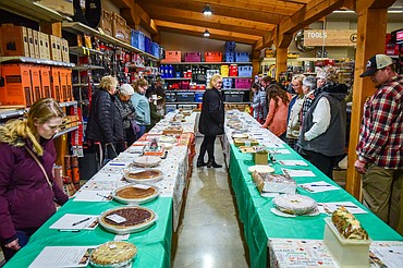 Attendees bid on pies during the silent auction at Light Up Evergreen & Pie Auction at Glacier Ace Hardware on Tuesday, Nov. 22. (Casey Kreider/Daily Inter Lake)