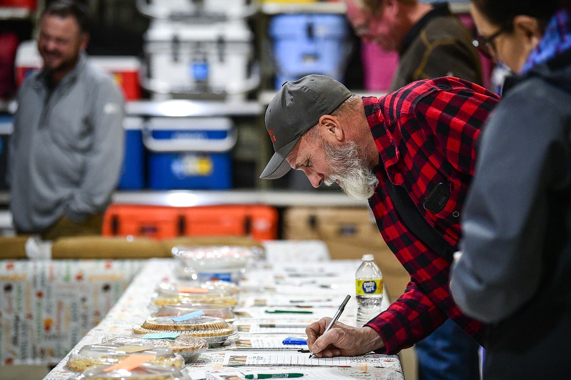 Attendees bid on pies during the silent auction at Light Up Evergreen & Pie Auction at Glacier Ace Hardware on Tuesday, Nov. 22. (Casey Kreider/Daily Inter Lake)