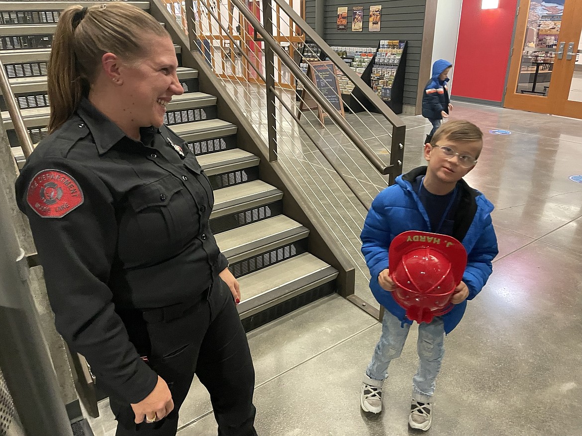 Moses Lake Fire Department Administrative Coordinator Heidi Merritt talks with Joshua Hardy after a city council meeting where the grade schooler and his sister Olive were honored for spotting a house fire and alerting their parents.