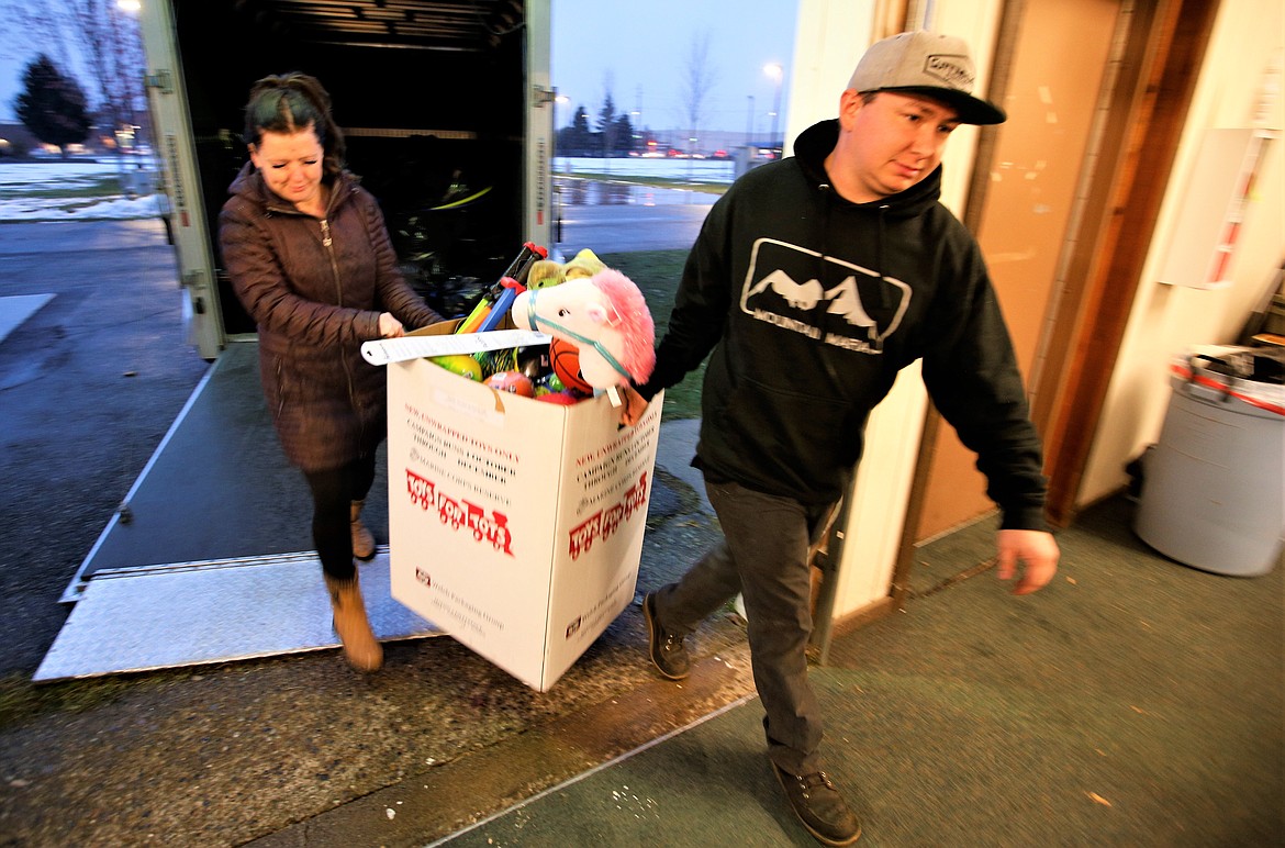 Jonathan and Alyssa Smith carry in toys on Tuesday being donated to Toys for Tots at its building at the Kootenai County Fairgrounds.