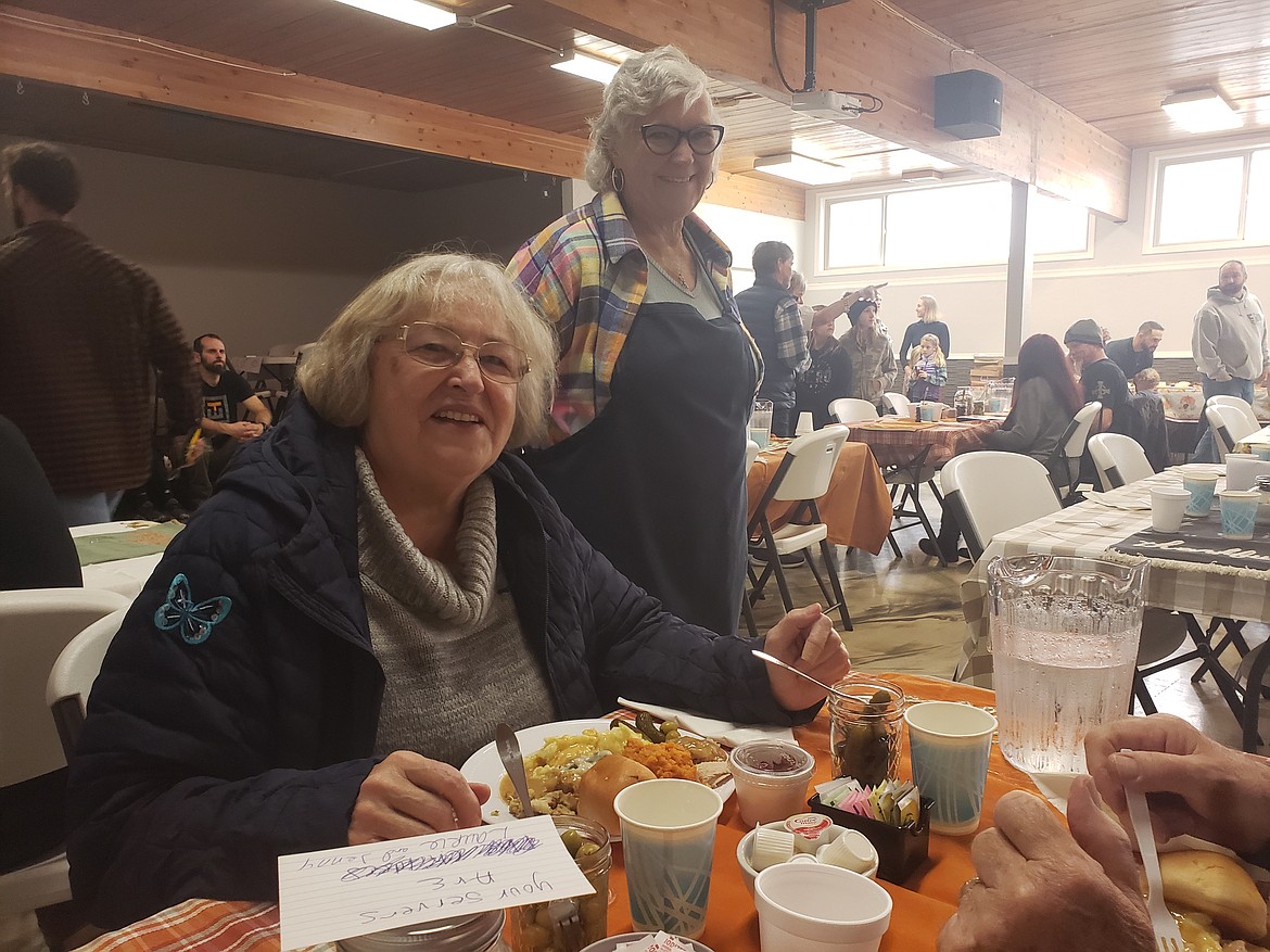 Debbie Sherer (left) enjoys a Thanksgiving dinner at the Altar Church on Thursday, where she also donated a dinner to the church. Jenny Lee (right) serves Sherer and others in the banquet hall to celebrate the holiday by giving back to the community.