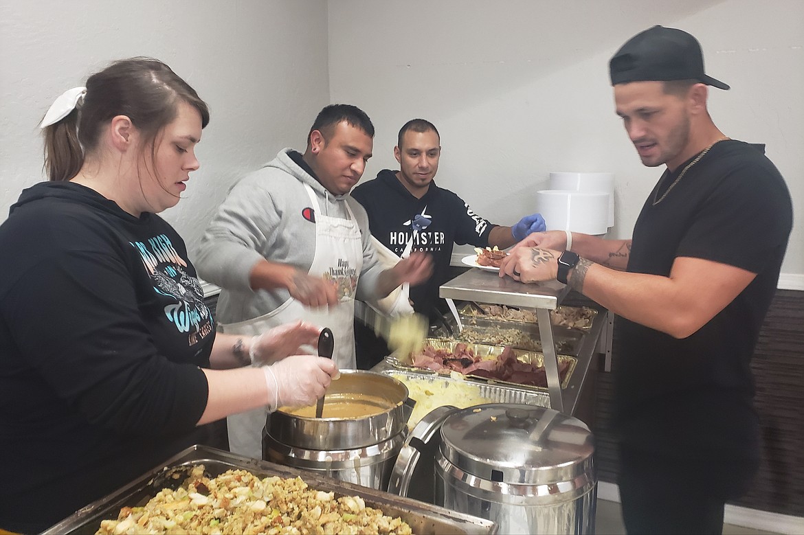 Set Apart Discipleship members (from left) Brooke Kettle, Johnny Vallejo, and Josh Moses serve food to volunteers who carry plates through the banquet hall in the Altar Church on Thanksgiving. Volunteers served nearly 400 meals in person and delivered over 100 meals to people unable to attend.