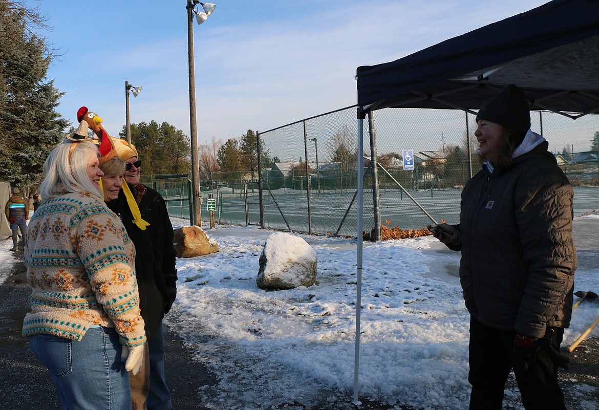 Bonner Community Food Bank executive director Debbie Love, right, takes a photo of Donna Davis, and her sister and brother-in-law, Brenda and Dale Rose as they wait for the start of the annual Turkey Trot event at Travers Park.