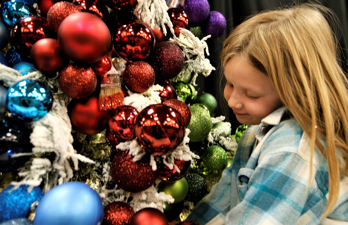 Kennedy Jacklin, 7, helps decorate the Berkshire Hathaway HomeServices Jacklin Real Estate tree for the Festival of Trees on Friday at The Coeur d'Alene Resort.