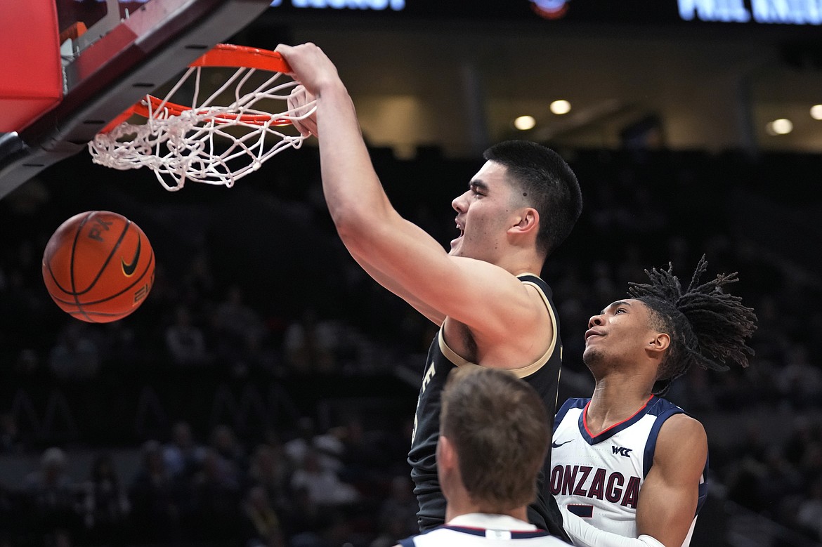 Purdue center Zach Edey dunks against Gonzaga guard Hunter Sallis, right, during the first half of an NCAA college basketball game in the Phil Knight Legacy tournament Friday, Nov. 25, 2022, in Portland, Ore.