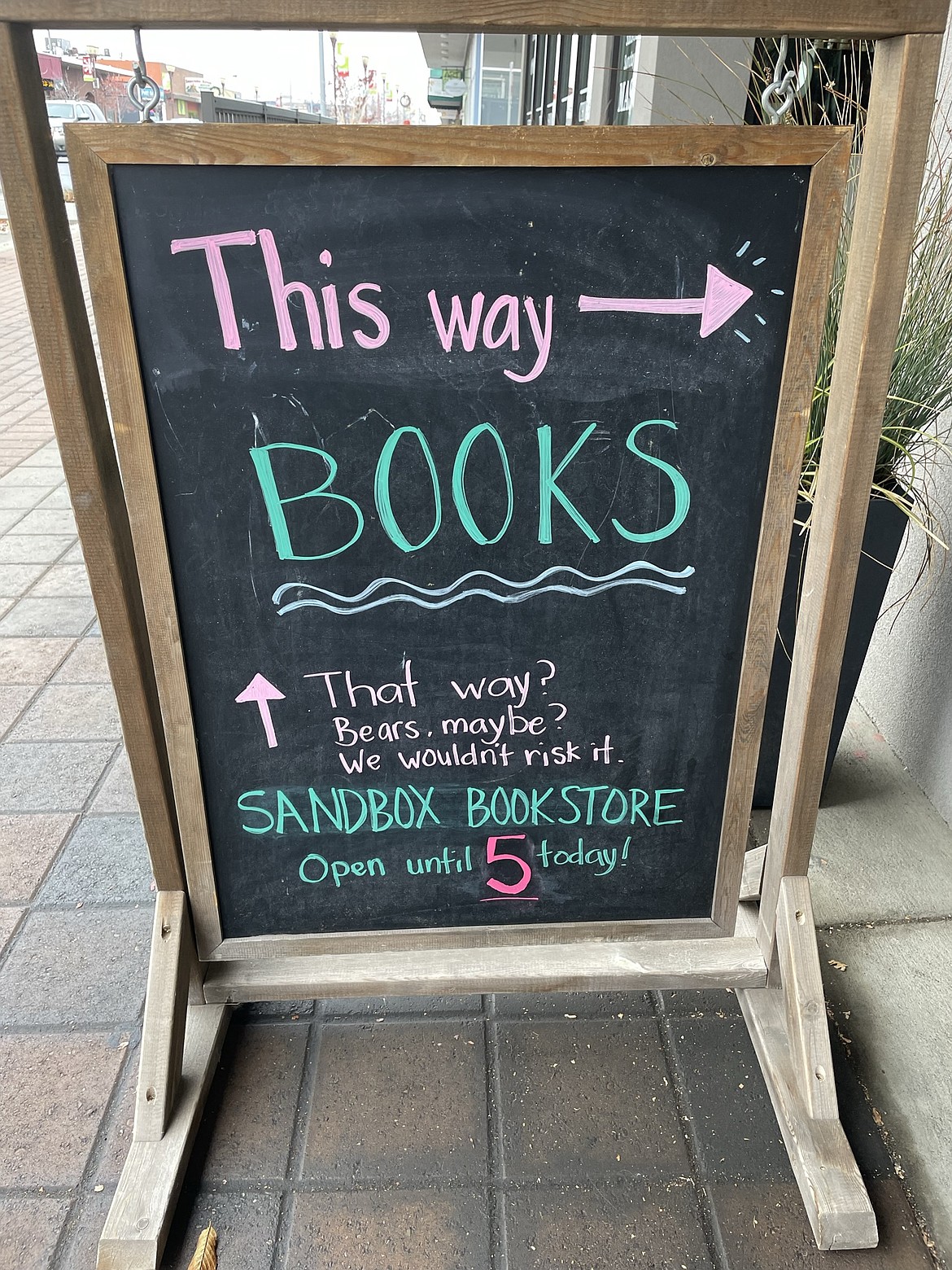 The sign in front of Sandbox Bookstore telling people where they can get books … and the threats that might be lurking elsewhere in downtown Moses Lake.