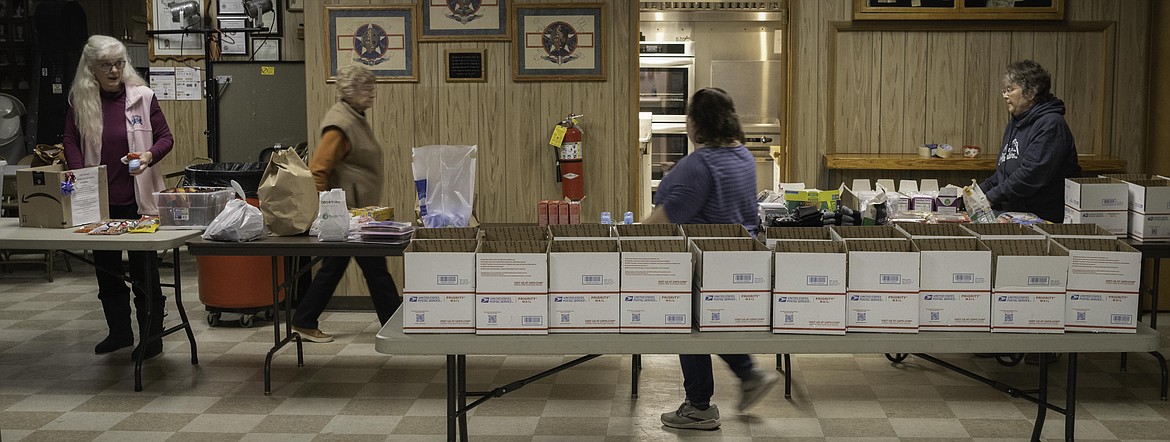 Volunteers at the VFW in Plains fill care packages to be sent to troops for the holiday season. (Tracy Scott/Valley Press)