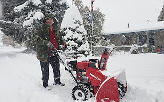 Fritzi Tegarden pauses, blowing off her sidewalk and driveway in Hayden on Wednesday as snow fills her path.