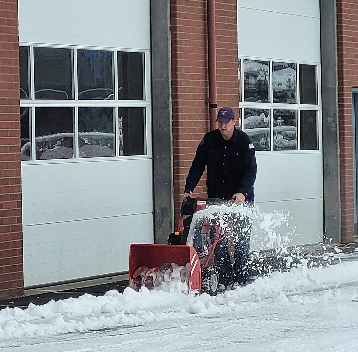 Firefighter Brian Russel runs a snowblower Wednesday morning to clear the snow from in front of bays at the city's fire station on Third Avenue. Keeping snow out of the way is part of ensuring first responders can get to those in need of aid.