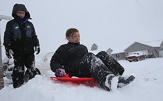 Hadley Still, 8, and Russell Covey, 9, play on a snow mound Wednesday in Hadley’s front yard in Post Falls.