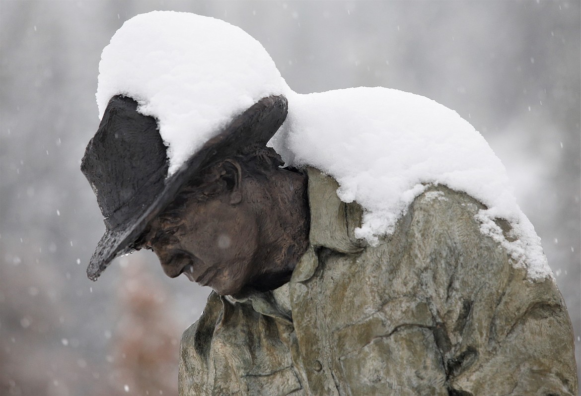 Snow covers a Terry Lee statue, "Idaho Farmer," on Front Avenue on Wednesday.