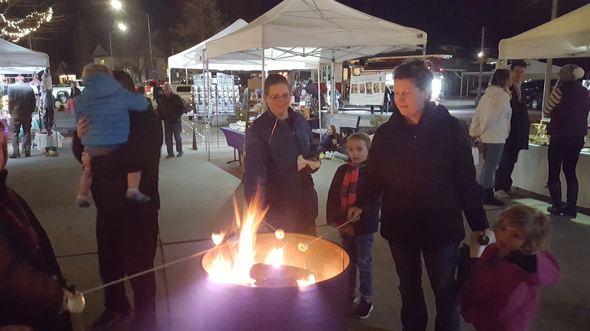 Guests roast marshmallows over burn barrels during the 2021 Winterfest and Plaza Market in Post Falls. This year's Winterfest is Friday.
