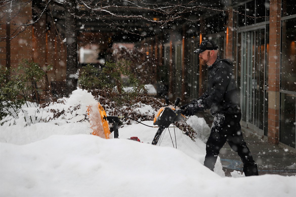 Aaron Frantz clears a sidewalk with a snowblower on Seventh Street in Coeur d'Alene on Wednesday.