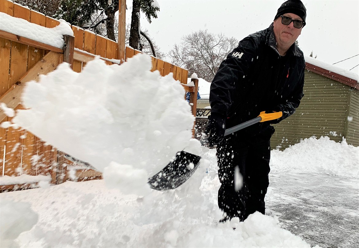 Jon Crane shovels snow in Coeur d'Alene on Wednesday.