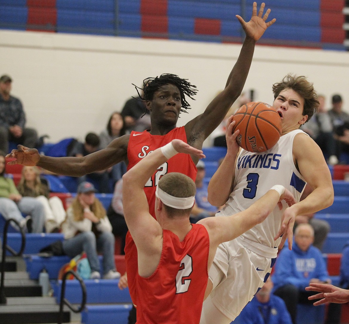 MARK NELKE/Press
Kruz Wheeler (3) of Coeur d’Alene goes up for a shot, surrounded by Ferris players Sam Markham (2) and Fareed Lawal, rear, in the first half Thursday night at Viking Court at Coeur d’Alene High.