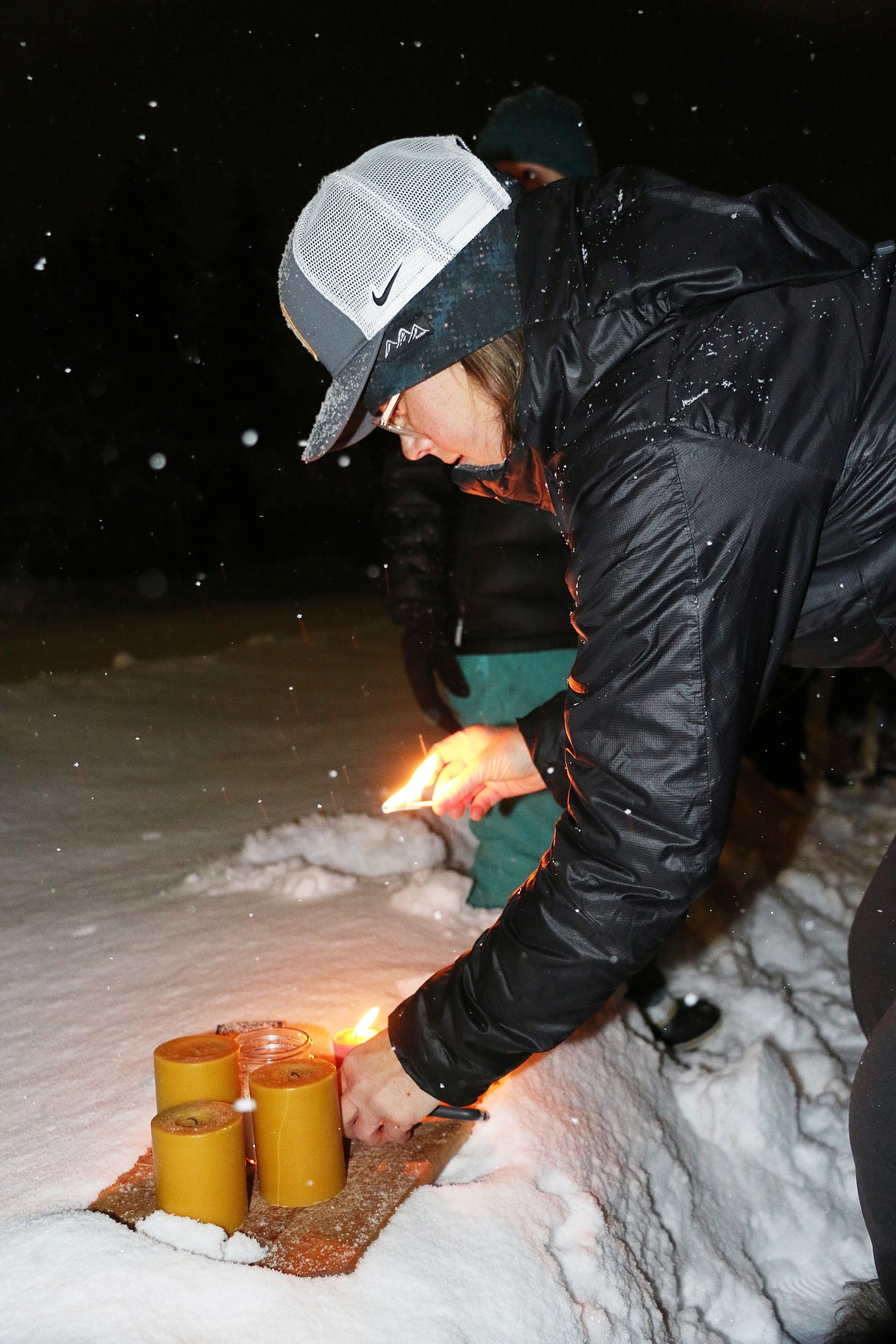 University of Idaho professor Elizabeth Wargo lights a candle at Lakeview Park during a candlelight vigil in Sandpoint to honor four UI students killed Nov. 13.