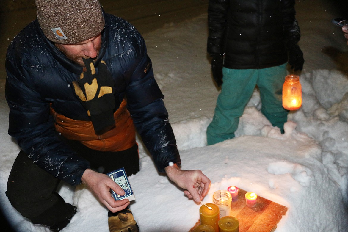 Sandpoint City Councilman Jason Welker lights a candle at Lakeview Park during a candlelight vigil in Sandpoint to honor four UI students killed Nov. 13.