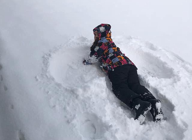 Bianca Walker looks up briefly from her snow angel Wednesday in Moses Lake.