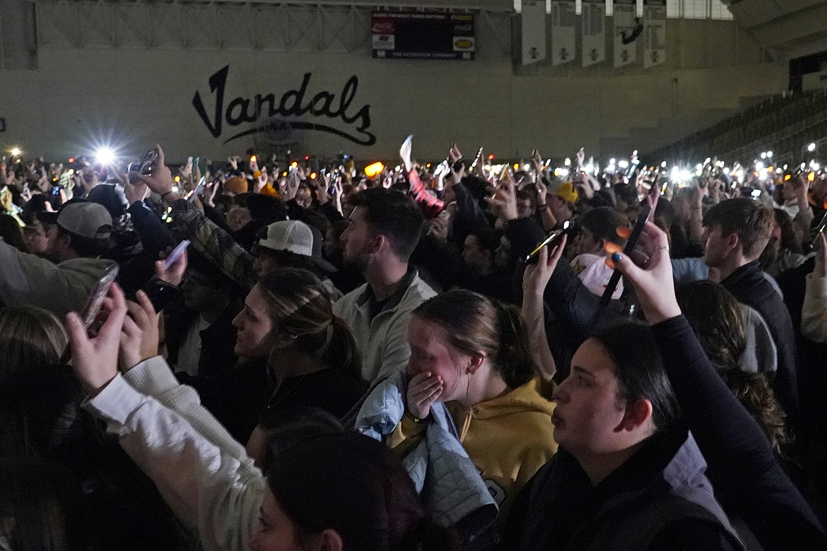 People attending a vigil for the four University of Idaho students who were killed on Nov. 13, 2022, hold up their phones during a moment of silence on Nov. 30, in Moscow. It's been nearly three weeks since four University of Idaho students were found stabbed to death in a home near campus, but there are still more questions than answers surrounding the investigation.