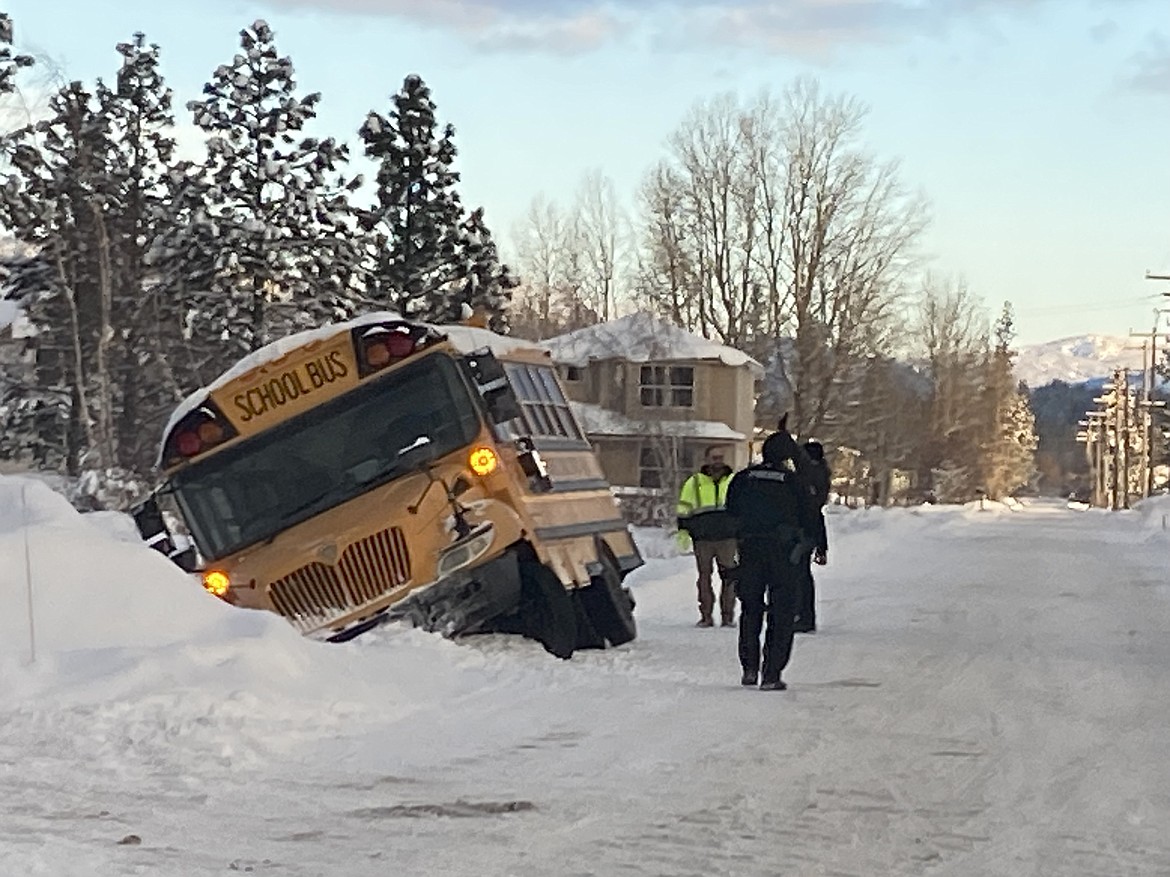 School district officials and Ponderay Police officers check out the scene after a Lake Pend Oreille School District bus slid off the road Friday morning.